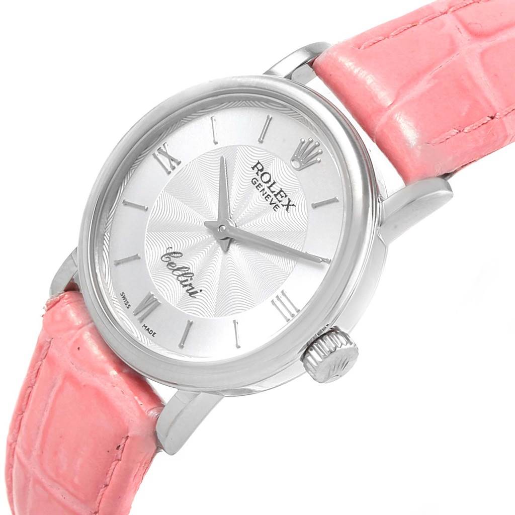 The angle shows the watch face, crown, and part of the pink strap of the Rolex Cellini 6110 Women's White Gold Silver Dial 6110 Women's White Gold Silver Dial model.