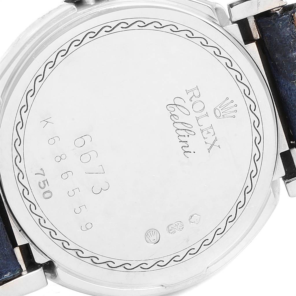 The image shows the back case of a Rolex Cellini 6673 Women's White Gold Silver Dial 6673 Women's White Gold Silver Dial watch, featuring engraved details and a partially visible strap.