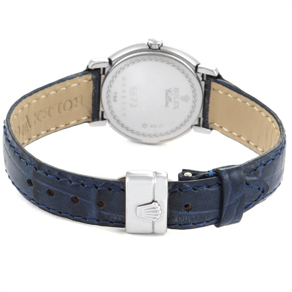 The image shows the back of a Rolex Cellini 6673 Women's White Gold Silver Dial 6673 Women's White Gold Silver Dial watch, featuring its case back, blue leather strap, and clasp.