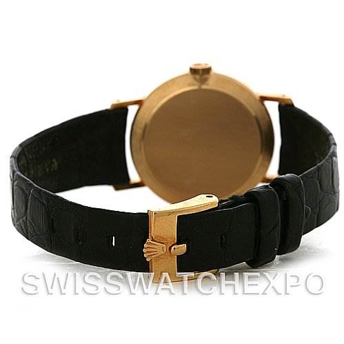 The image shows the back view of a Rolex Cellini 4109 Women's Yellow Gold White Dial 4109 Women's Yellow Gold White Dial watch, highlighting its black strap and gold clasp.