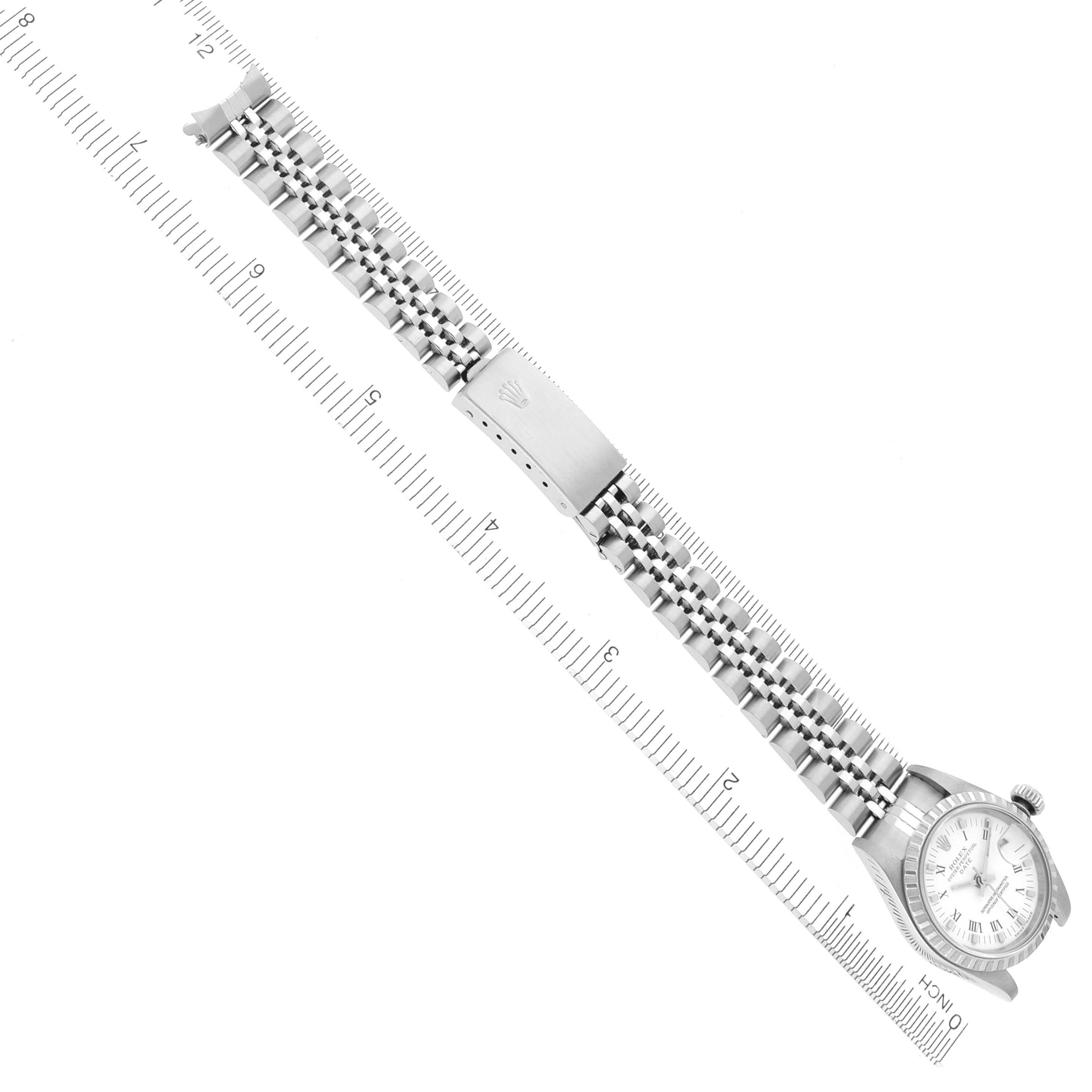 The image shows a Rolex Date 79240 Women's Stainless Steel White Dial 79240 Women's Stainless Steel White Dial watch from a top-down angle, highlighting its bracelet and clasp alongside a ruler for scale.