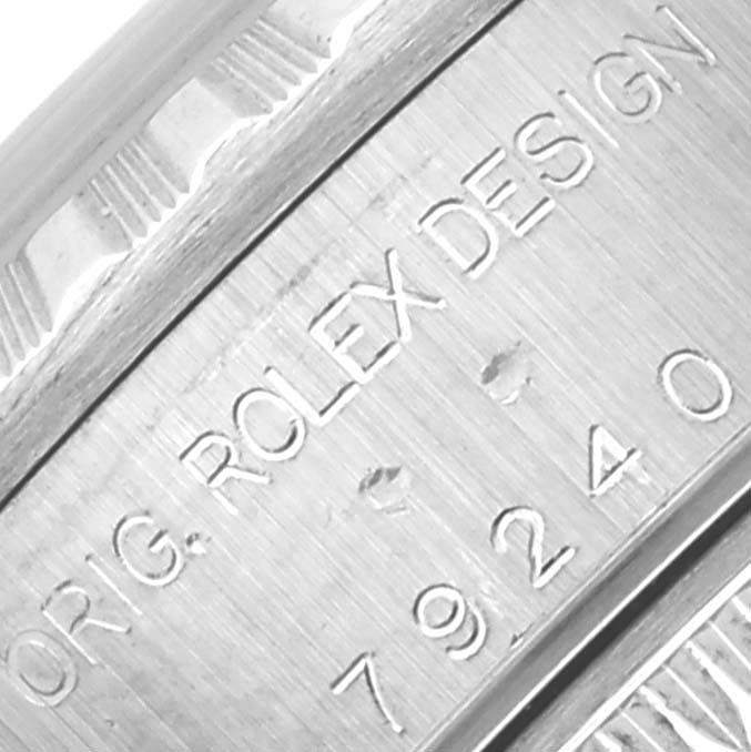 The image shows a close-up of the side of a Rolex Date 79240 Women's Stainless Steel White Dial 79240 Women's Stainless Steel White Dial model, featuring engraved text and the case design details.