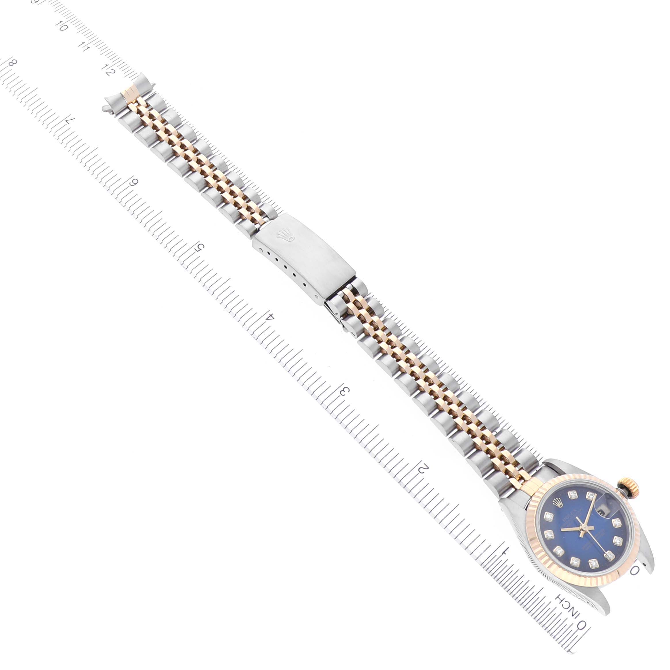 The image shows a Rolex Datejust 69173 Women's Steel and Gold (two tone) Blue Dial 69173 Women's Steel and Gold (two tone) Blue Dial from an angled top view, displaying the full bracelet, clasp, and watch face with rulers at the sides.