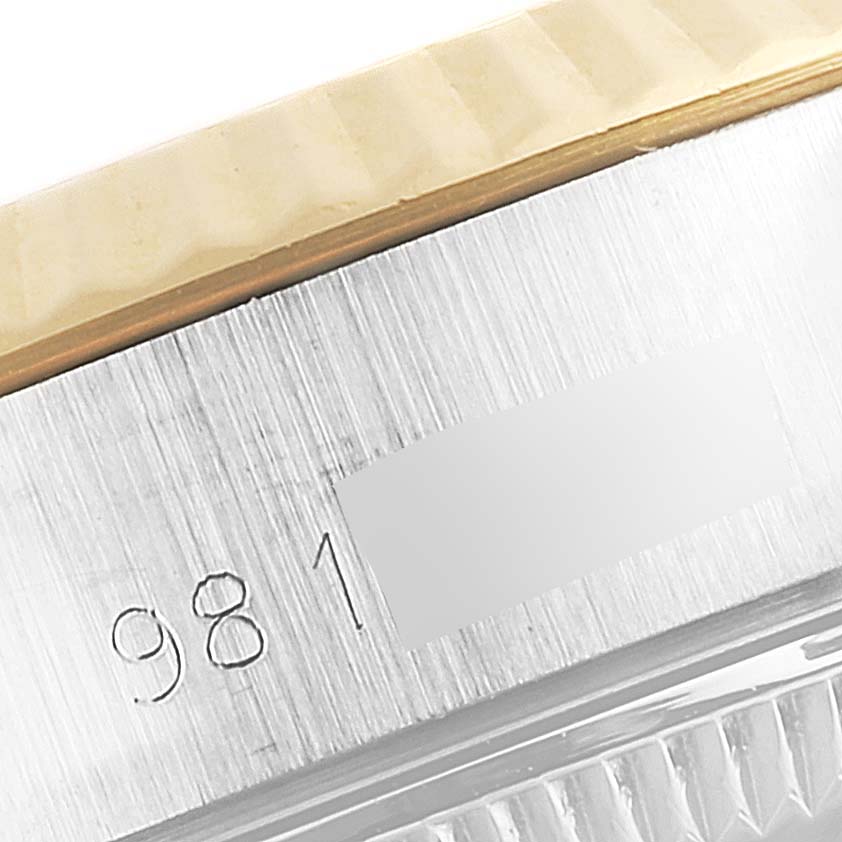 This close-up image of the Rolex Datejust 69173 Women's Steel and Gold (two tone) Champagne Dial 69173 Women's Steel and Gold (two tone) Champagne Dial watch shows part of the case and bezel, revealing a portion of the serial number.