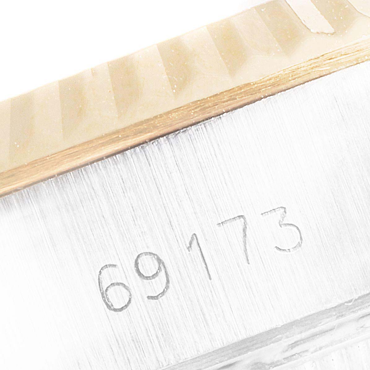 This close-up image shows the case and part of the fluted bezel of a Rolex Datejust 69173 Women's Steel and Gold (two tone) Champagne Dial 69173 Women's Steel and Gold (two tone) Champagne Dial watch, with the serial number "69173" engraved.