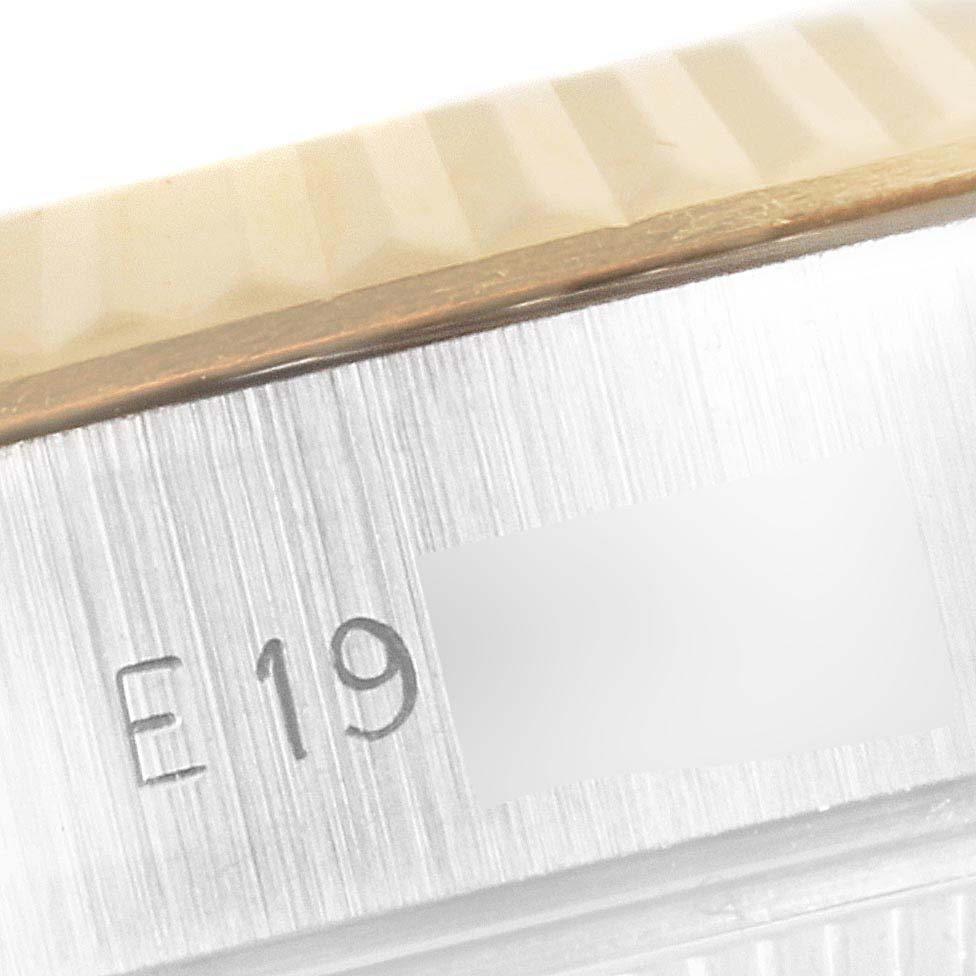 This image is a close-up of the side of a Rolex Datejust 69173 Women's Steel and Gold (two tone) Champagne Dial 69173 Women's Steel and Gold (two tone) Champagne Dial watch showing the serial number and part of the fluted bezel.