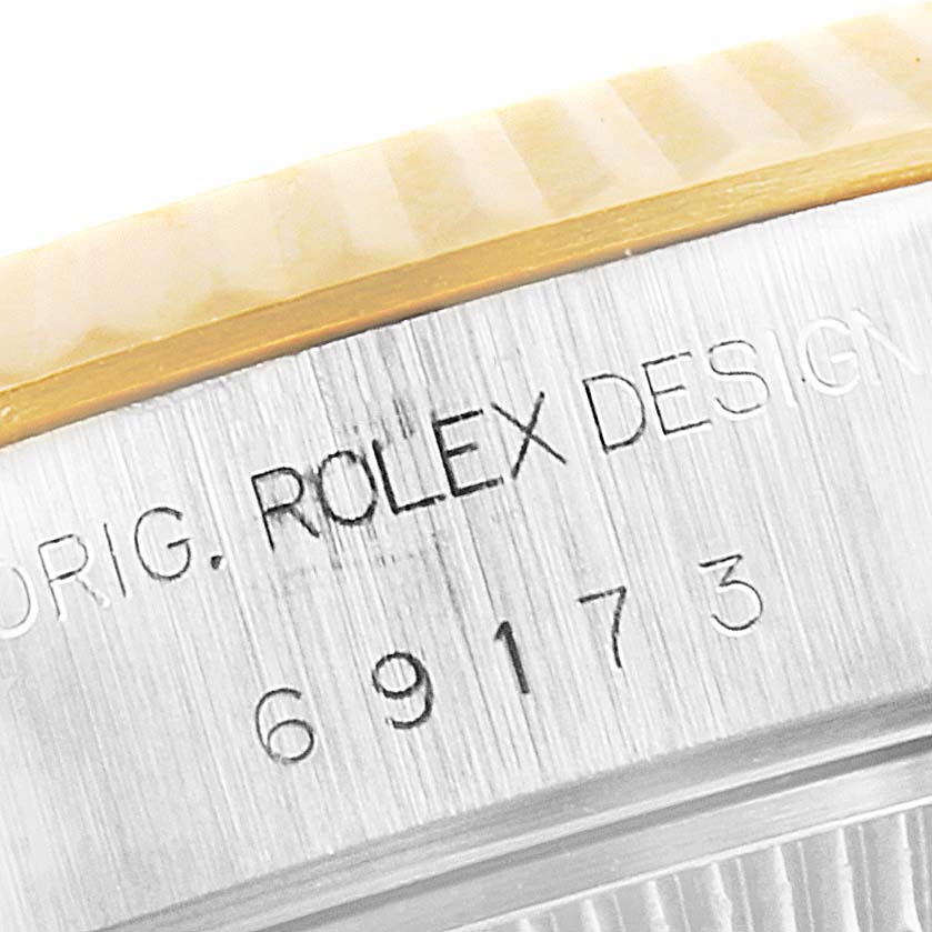 The image shows a close-up of the side of a Rolex Datejust 69173 Women's Steel and Gold (two tone) Champagne Dial 69173 Women's Steel and Gold (two tone) Champagne Dial watch case, featuring the model number and engraving.