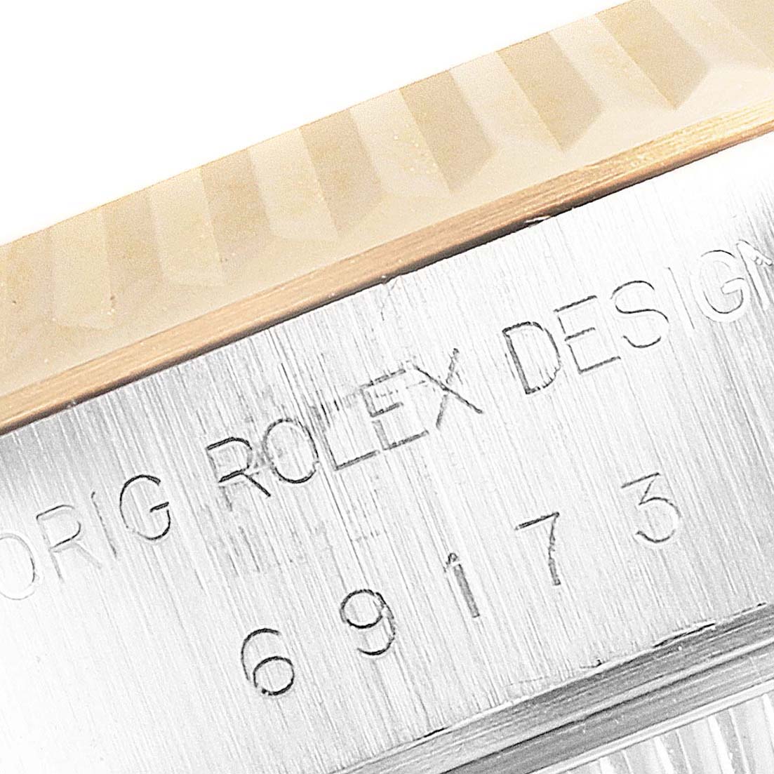 This image shows a close-up of the engraved serial number and fluted bezel of a Rolex Datejust 69173 Women's Steel and Gold (two tone) Champagne Dial 69173 Women's Steel and Gold (two tone) Champagne Dial watch.
