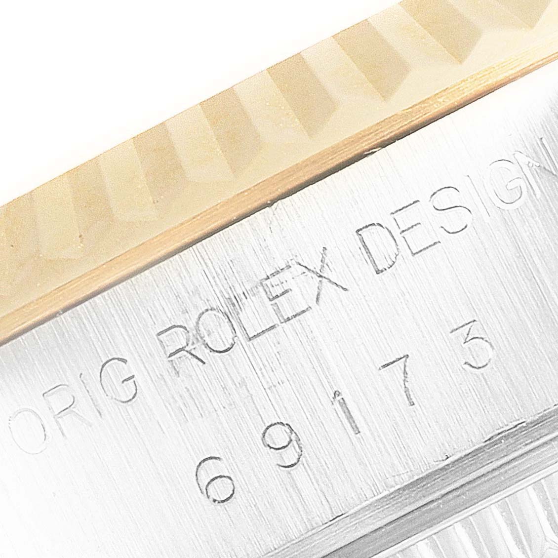 This close-up image shows the edge of the bezel and part of the casing with the engraving on a Rolex Datejust 69173 Women's Steel and Gold (two tone) Champagne Dial 69173 Women's Steel and Gold (two tone) Champagne Dial watch.