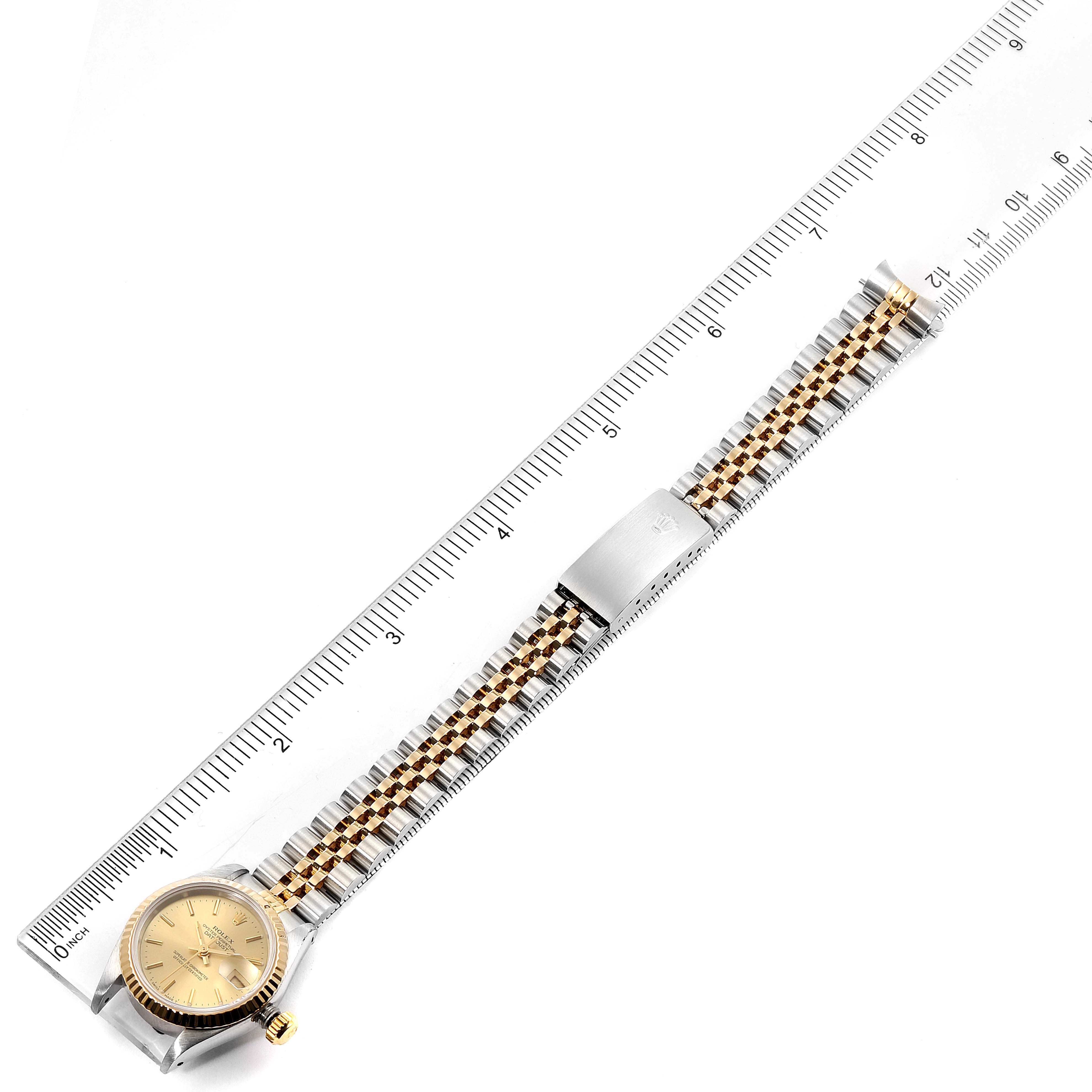 The image shows a side angle of a Rolex Datejust 69173 Women's Steel and Gold (two tone) Champagne Dial 69173 Women's Steel and Gold (two tone) Champagne Dial watch, with its whole band and clasp extended next to a ruler.