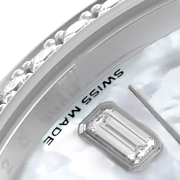 This close-up of the Rolex President 118346NG Men's Platinum Mother of Pearl Dial 118346NG Men's Platinum Mother of Pearl Dial watch shows part of the bezel with diamonds and the "Swiss Made" label on the dial.
