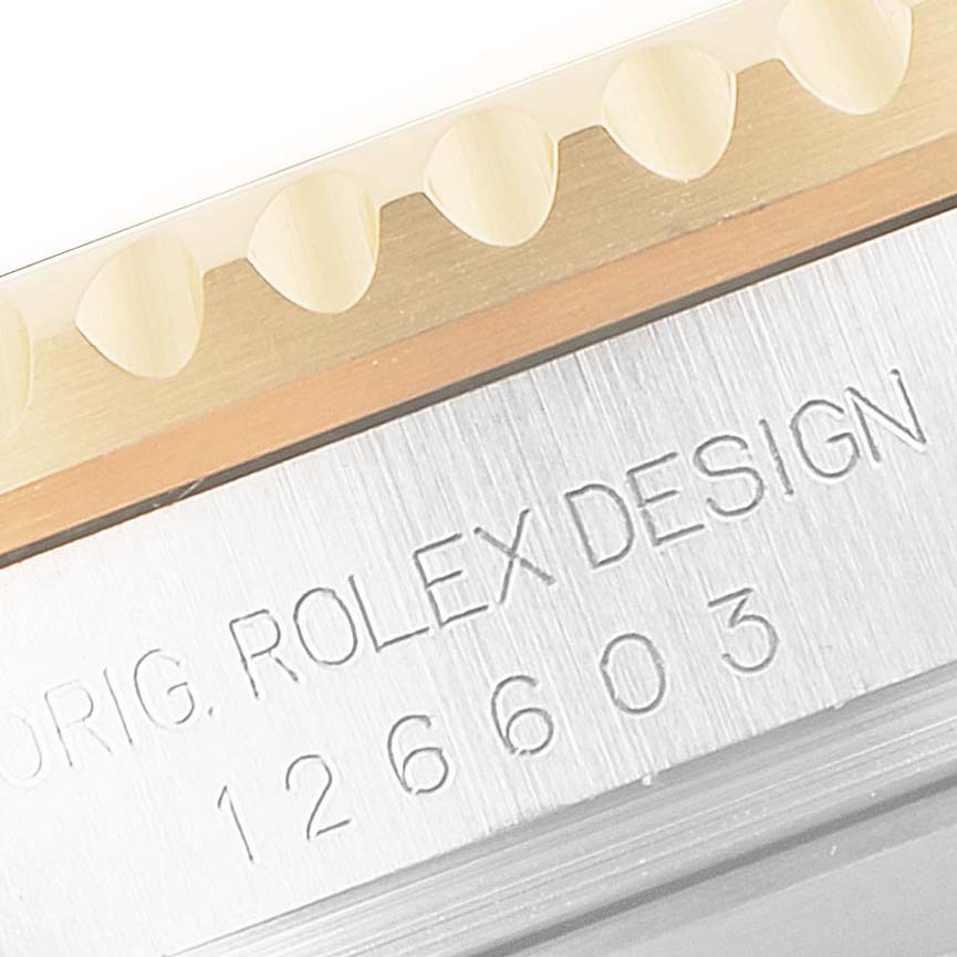 This image shows a close-up of the side of a Rolex Sea-Dweller 126603 Men's Steel and Gold (two tone) Black Dial 126603 Men's Steel and Gold (two tone) Black Dial watch, highlighting the engraved "ROLEX DESIGN" text and serial number.