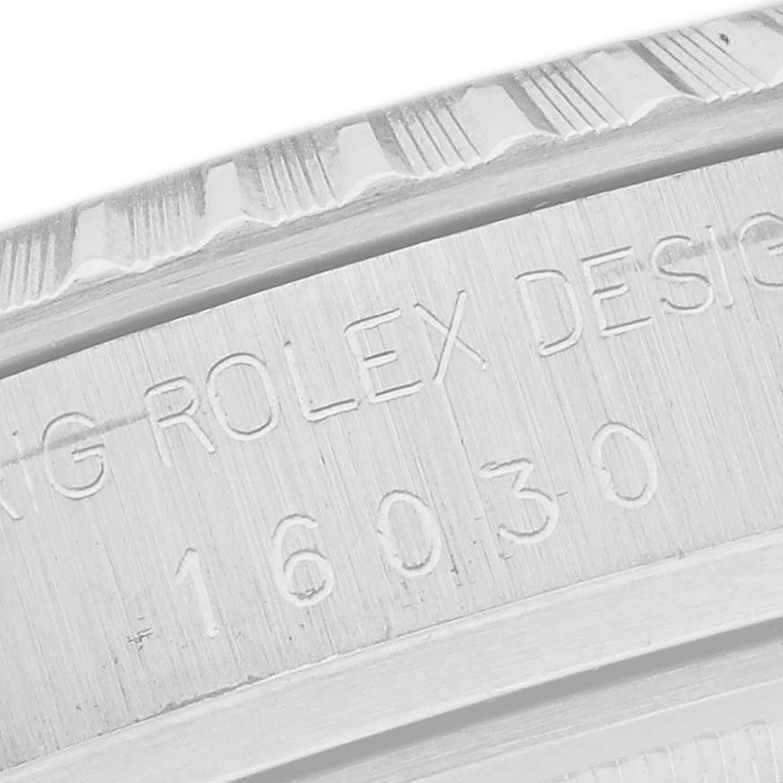 The image shows the side of a Rolex Datejust 16030 Men's Stainless Steel Silver Dial 16030 Men's Stainless Steel Silver Dial case with engraved text detailing the model number.