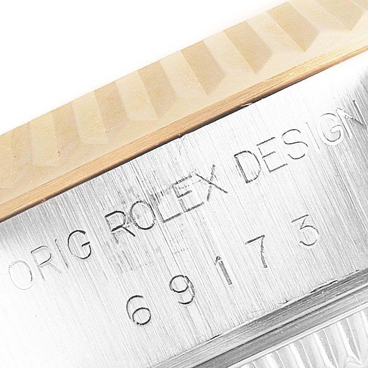 This close-up image shows the fluted bezel and the engraved serial number of a Rolex Datejust 69173 Women's Steel and Gold (two tone) Champagne Dial 69173 Women's Steel and Gold (two tone) Champagne Dial watch.