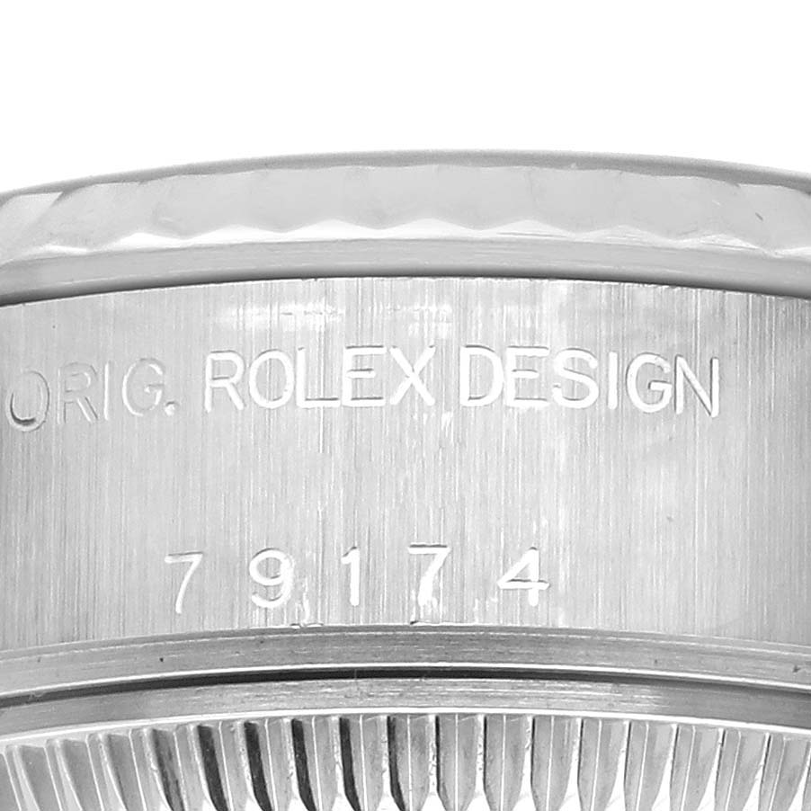 The image shows a close-up of the side view of a Rolex Datejust 79174 Women's Stainless Steel Black Dial 79174 Women's Stainless Steel Black Dial, focusing on the case with engraved text.