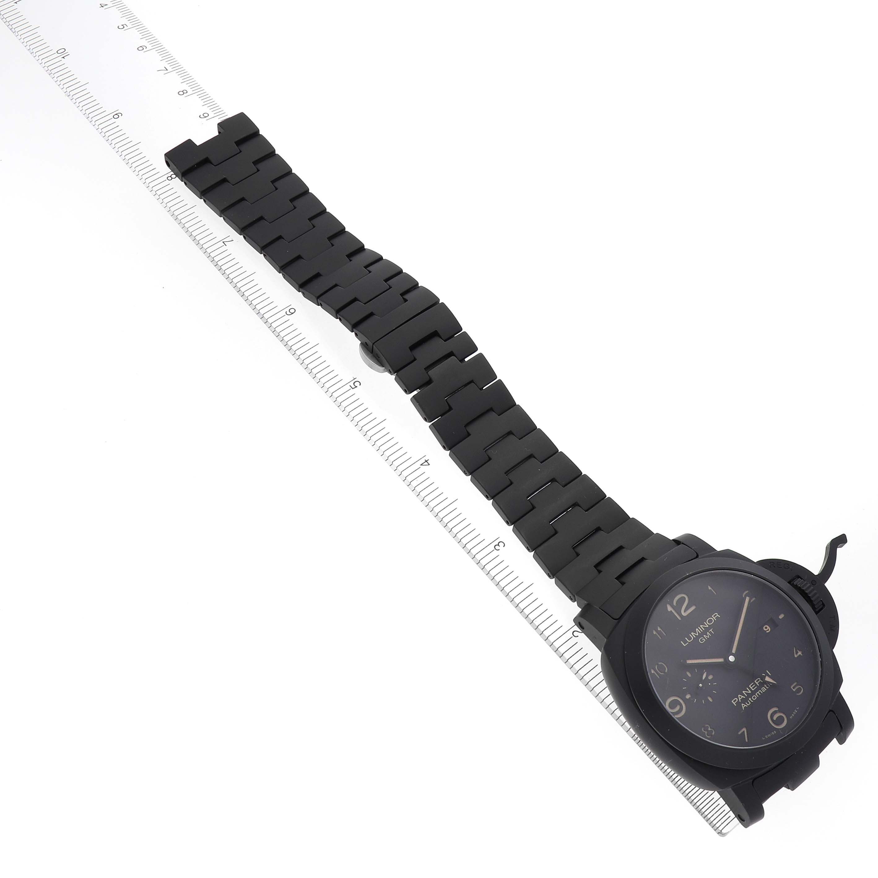 The Panerai Luminor PAM01438 Men's Ceramic Black Dial PAM01438 Men's Ceramic Black Dial watch is shown at an angle, displaying the face, bracelet, and clasp alongside a measuring ruler.