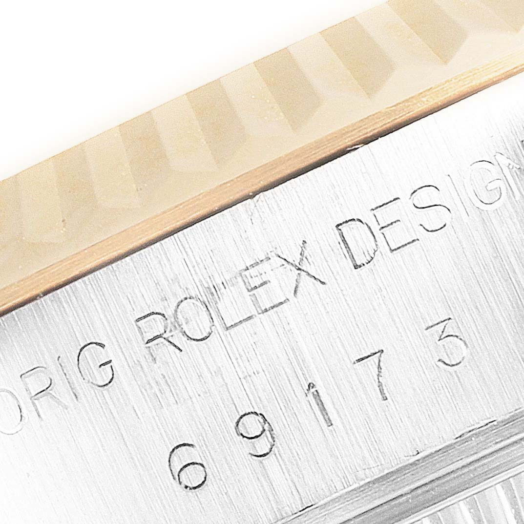 The image shows a close-up of the Rolex Datejust 69173 Women's Steel and Gold (two tone) Champagne Dial 69173 Women's Steel and Gold (two tone) Champagne Dial's fluted bezel and part of the engraved casing.