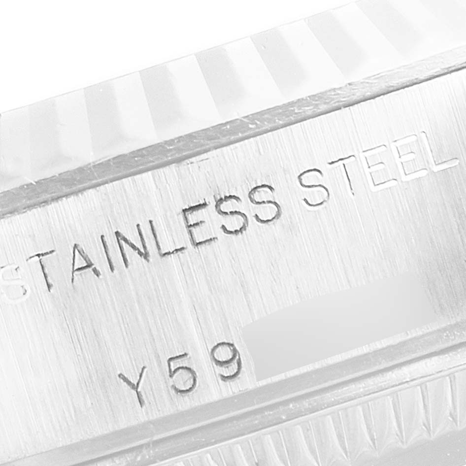 The image shows a close-up of the side of a Rolex Datejust 79174 Women's Stainless Steel Pink Dial 79174 Women's Stainless Steel Pink Dial watch, highlighting the "STAINLESS STEEL" engraving and a partial serial number.