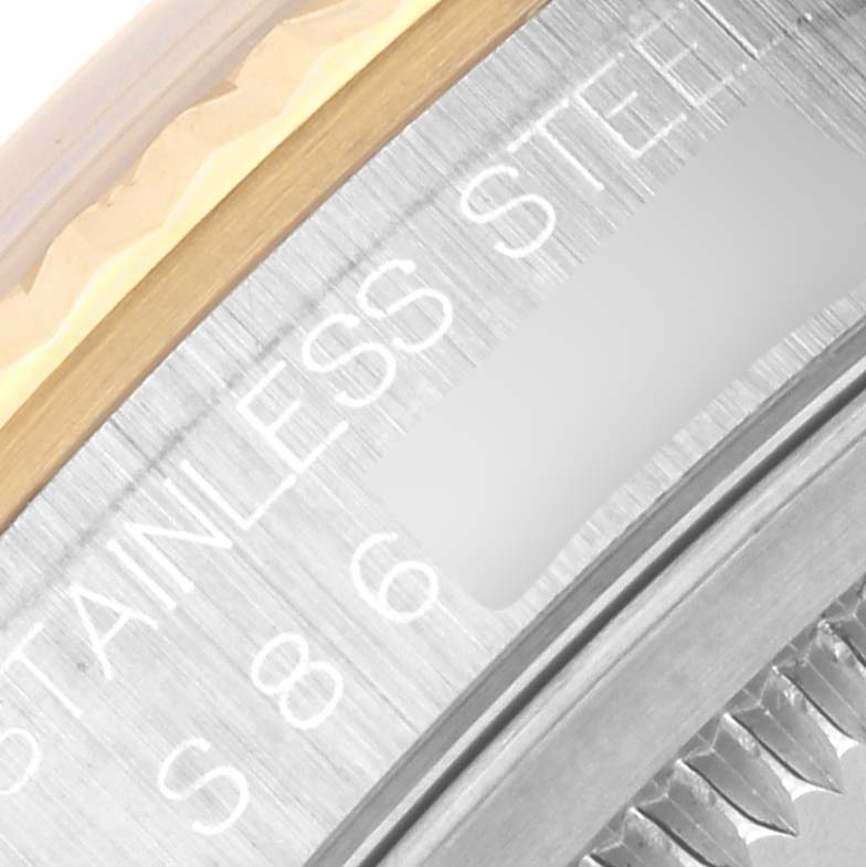 The image shows a close-up of the Rolex Datejust 16233 Men's Steel and Gold (two tone) White Dial 16233 Men's Steel and Gold (two tone) White Dial's steel and gold bezel, partially displaying "STAINLESS STEEL."