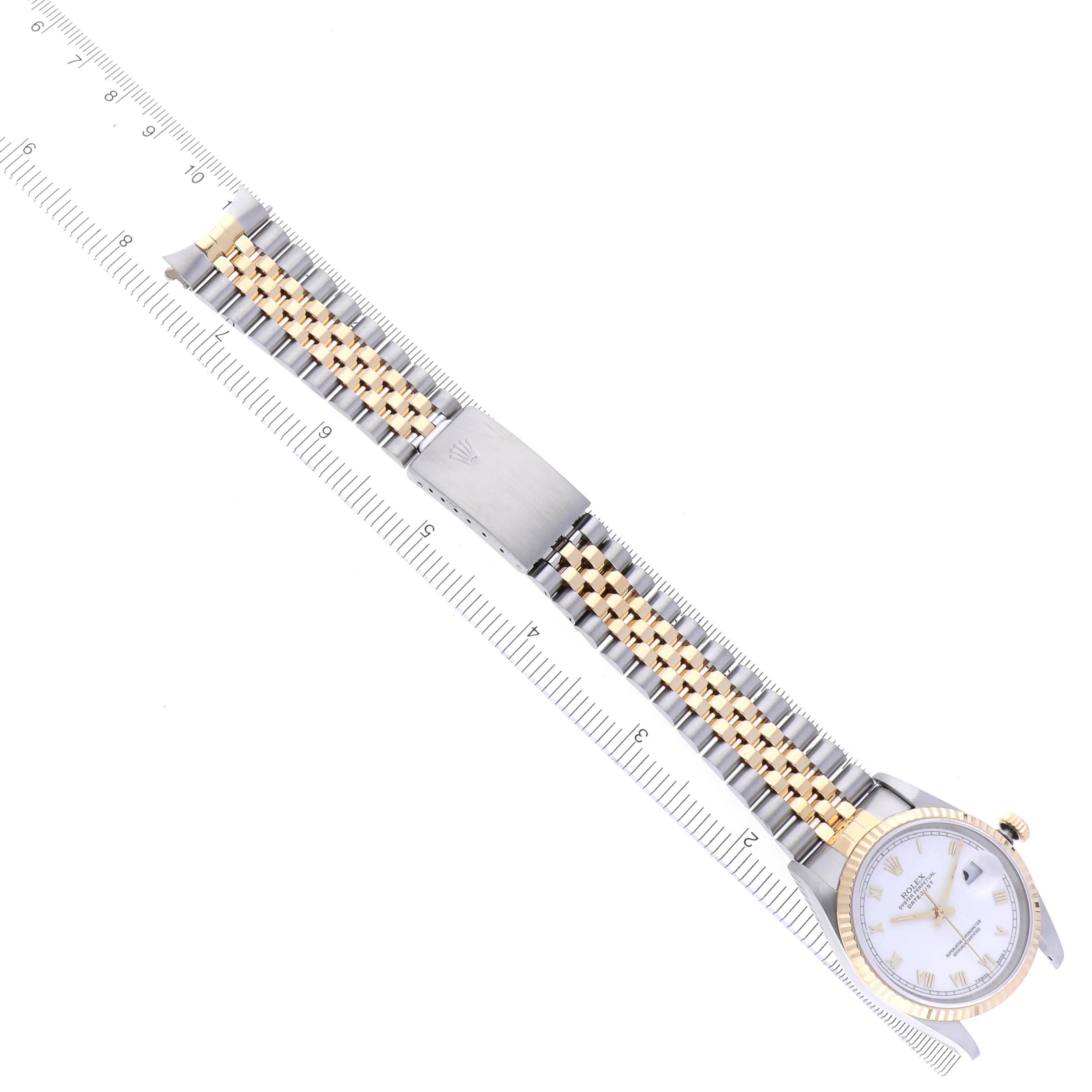 The Rolex Datejust 16233 Men's Steel and Gold (two tone) White Dial 16233 Men's Steel and Gold (two tone) White Dial watch is displayed flat, showing the face, two-tone bracelet, and clasp alongside a ruler for scale.