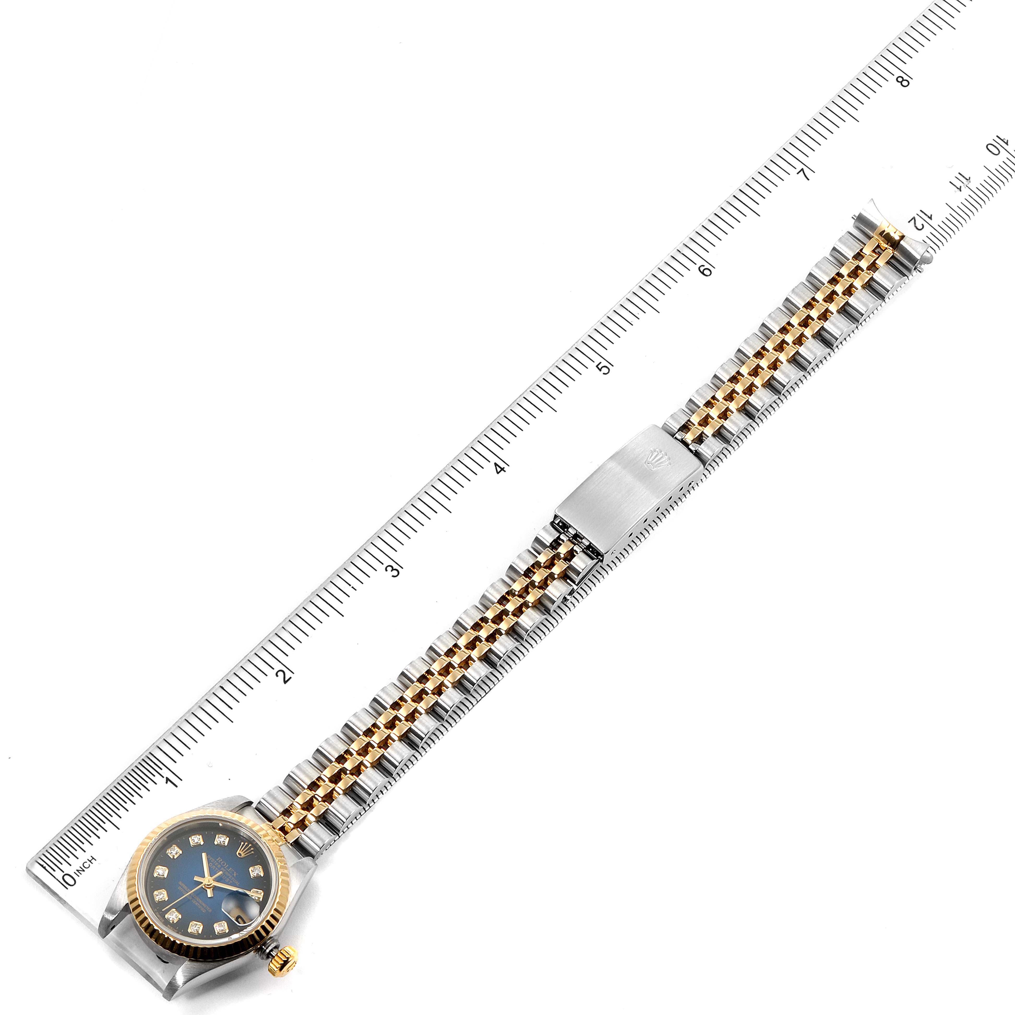 This image shows a top view of a Rolex Datejust 69173 Women's Steel and Gold (two tone) Blue Dial 69173 Women's Steel and Gold (two tone) Blue Dial watch, including its full bracelet alongside a measuring ruler.