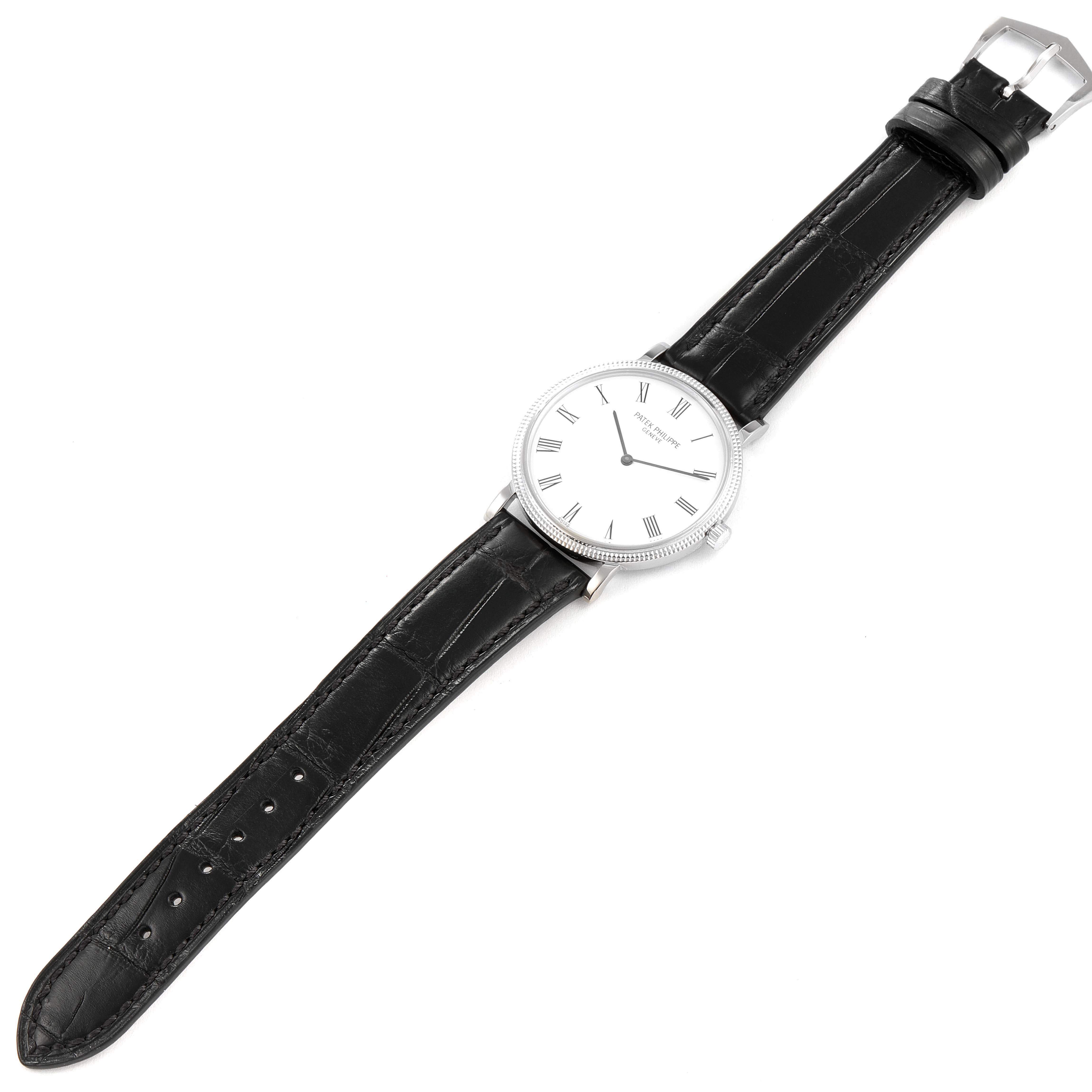 This image shows a Patek Philippe Calatrava 5120G Men's White Gold White Dial 5120G Men's White Gold White Dial watch laid flat, highlighting the watch face, black leather strap, and silver buckle.