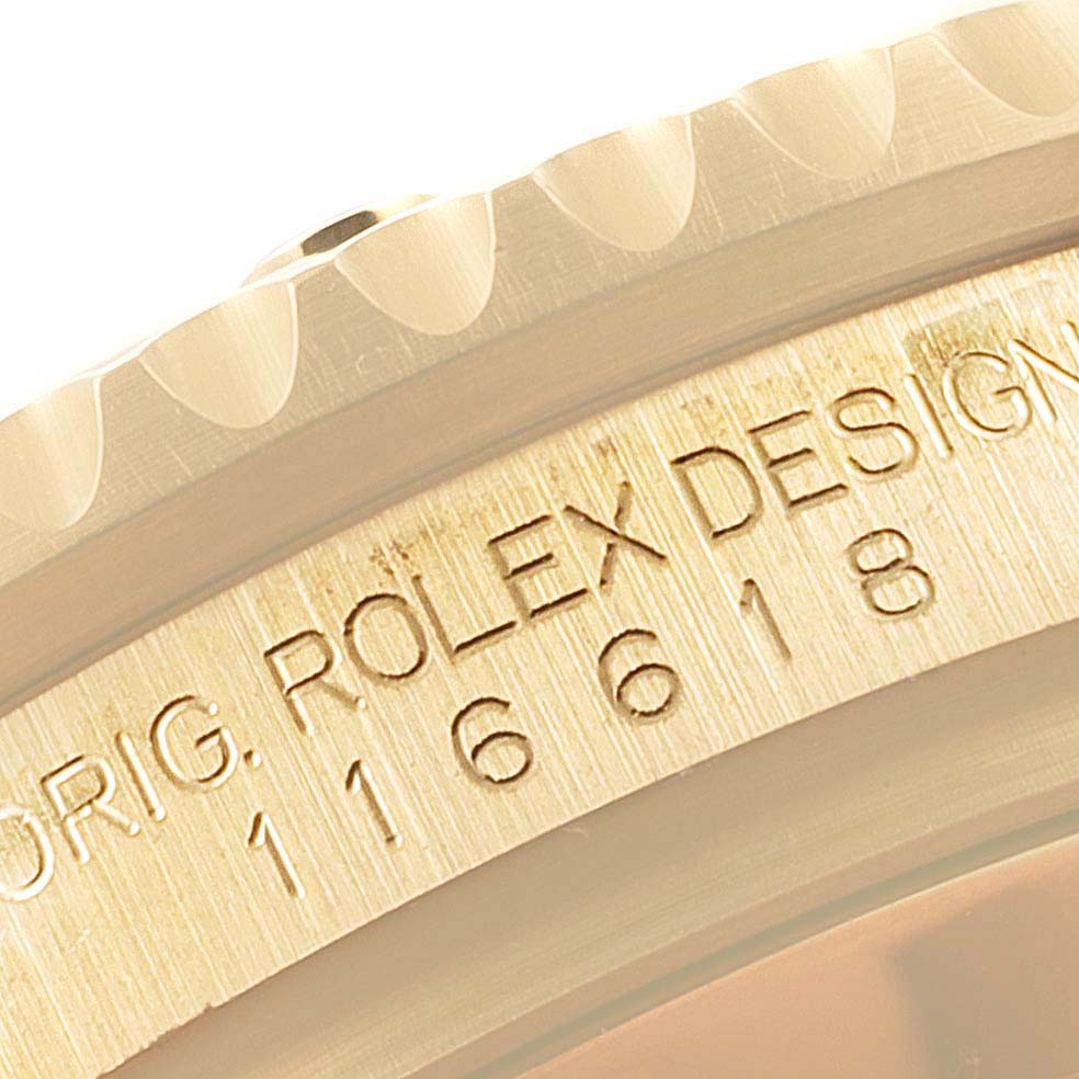 This close-up image shows the engraved model number and part of the bezel of a Rolex Submariner 116618 Men's Yellow Gold Black Dial 116618 Men's Yellow Gold Black Dial watch.