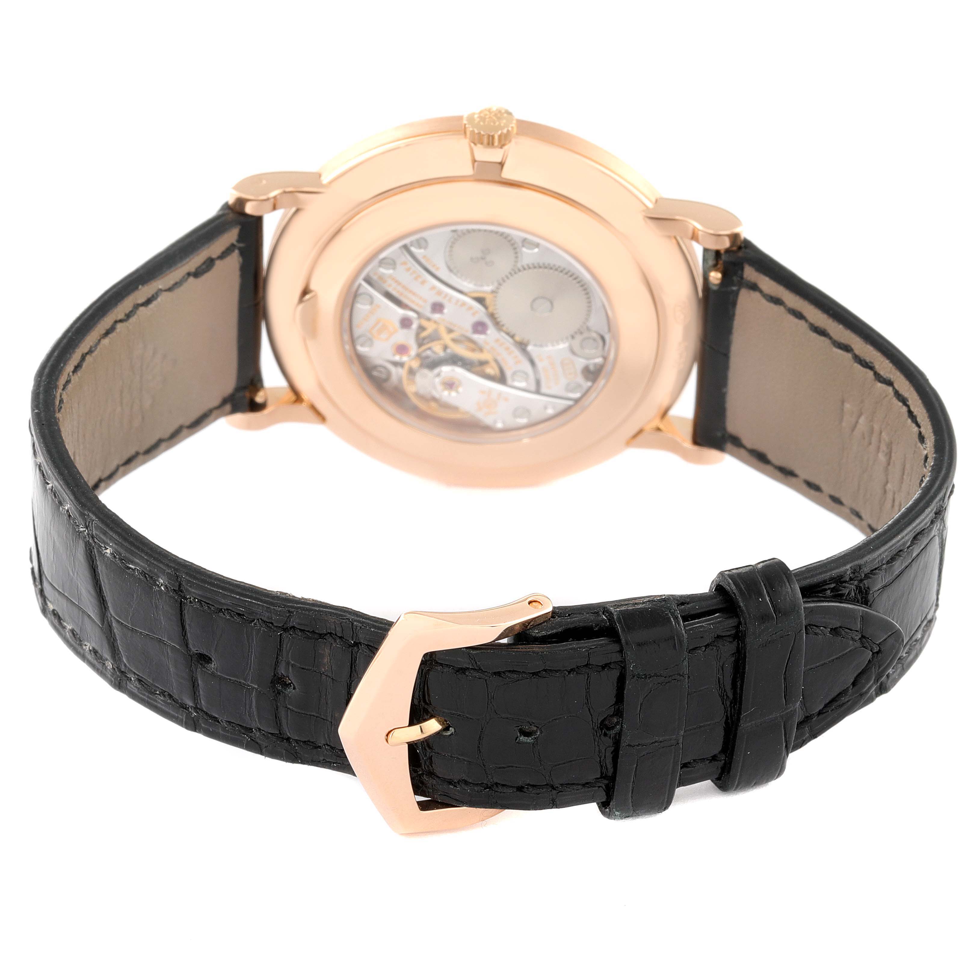 The image shows the back of a Patek Philippe Calatrava 5116R Men's Rose Gold White Dial 5116R Men's Rose Gold White Dial watch with its open case back and black leather strap.