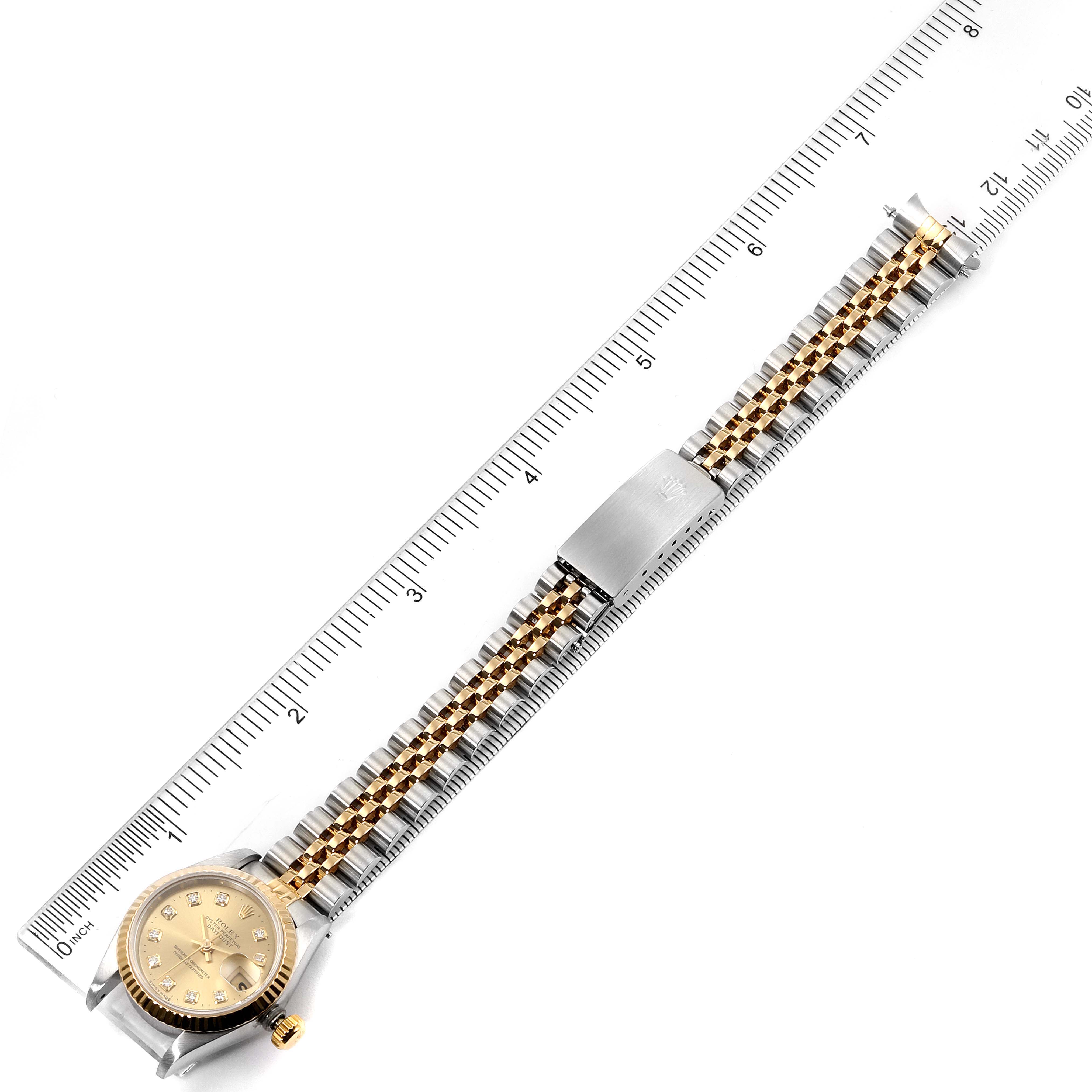 The image shows a Rolex Datejust 69173 Women's Steel and Gold (two tone) Champagne Dial 69173 Women's Steel and Gold (two tone) Champagne Dial watch lying flat with a ruler, highlighting its bracelet and face.