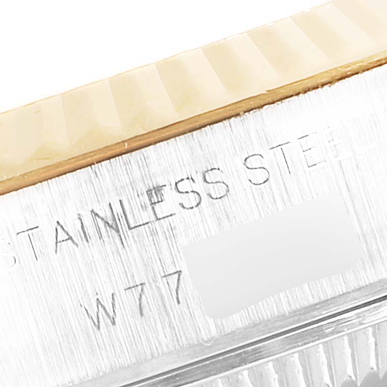 The image shows a close-up of the casing side of a Rolex Datejust 69173 Women's Steel and Gold (two tone) Champagne Dial 69173 Women's Steel and Gold (two tone) Champagne Dial watch, displaying part of the fluted bezel and inscribed text "STAINLESS STEEL".