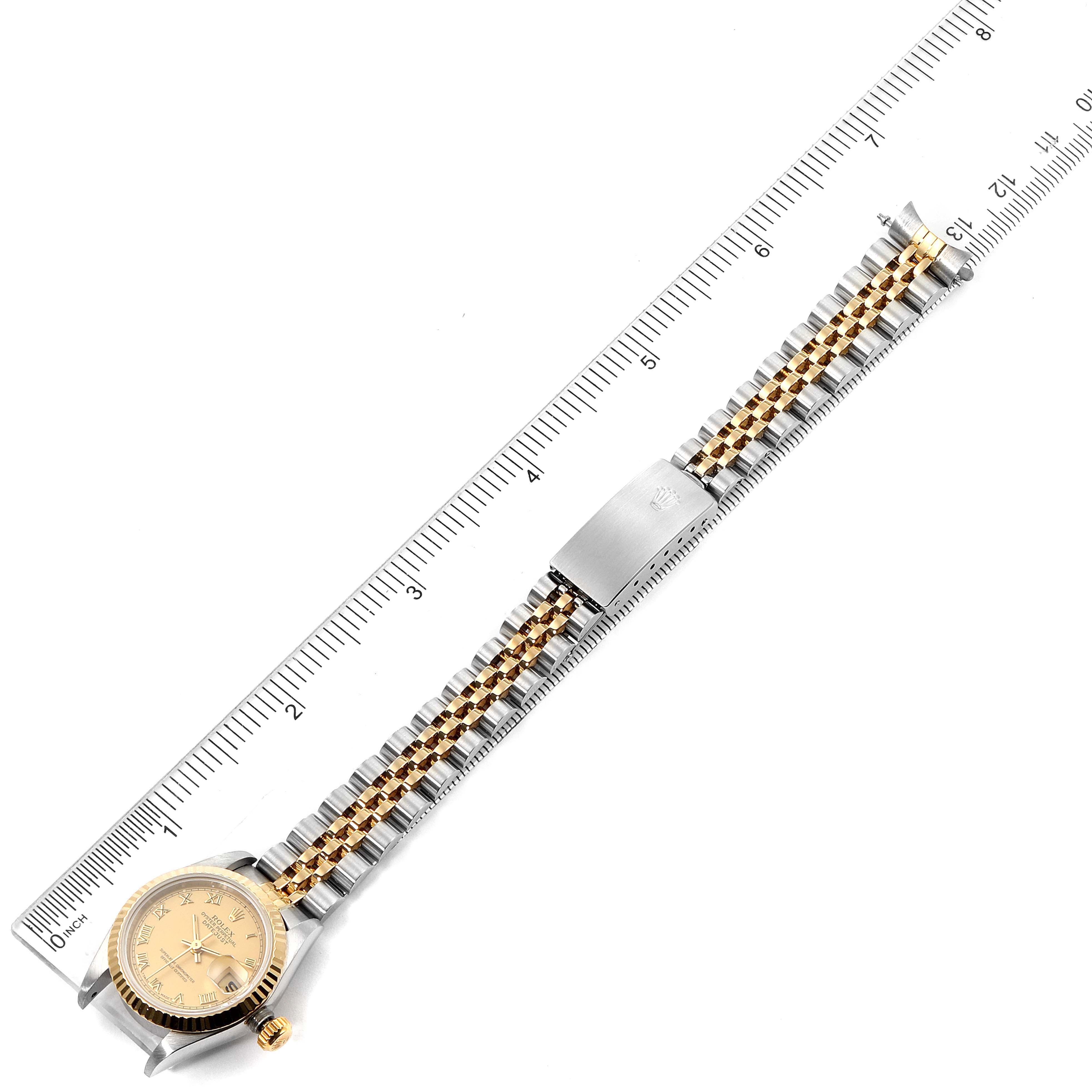 The Rolex Datejust 69173 Women's Steel and Gold (two tone) Champagne Dial 69173 Women's Steel and Gold (two tone) Champagne Dial watch is shown from the top angle, with its face, bracelet, and clasp visible, alongside a ruler for size reference.