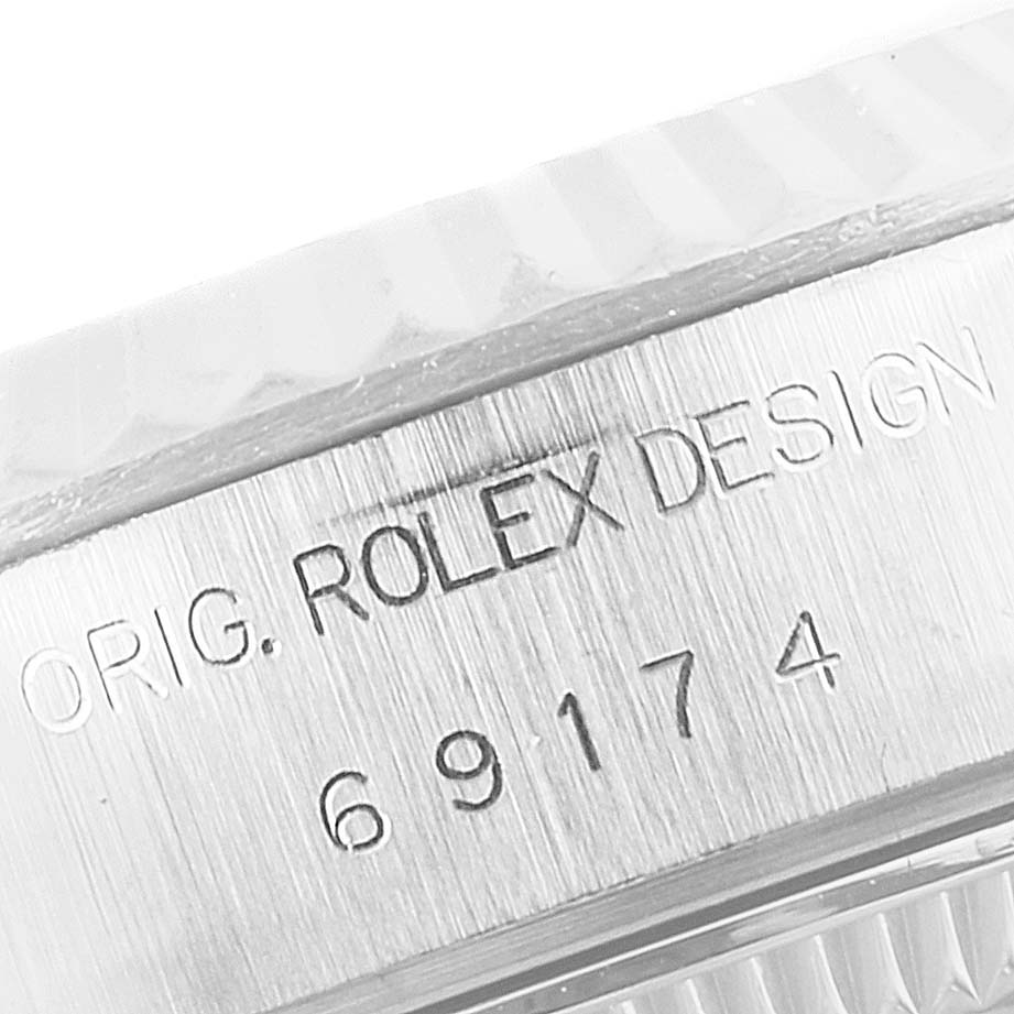 This image shows a close-up of the engraved case side of a Rolex Datejust 69174 Women's Stainless Steel Silver Dial 69174 Women's Stainless Steel Silver Dial watch with the model number and "ROLEX DESIGN" inscription.