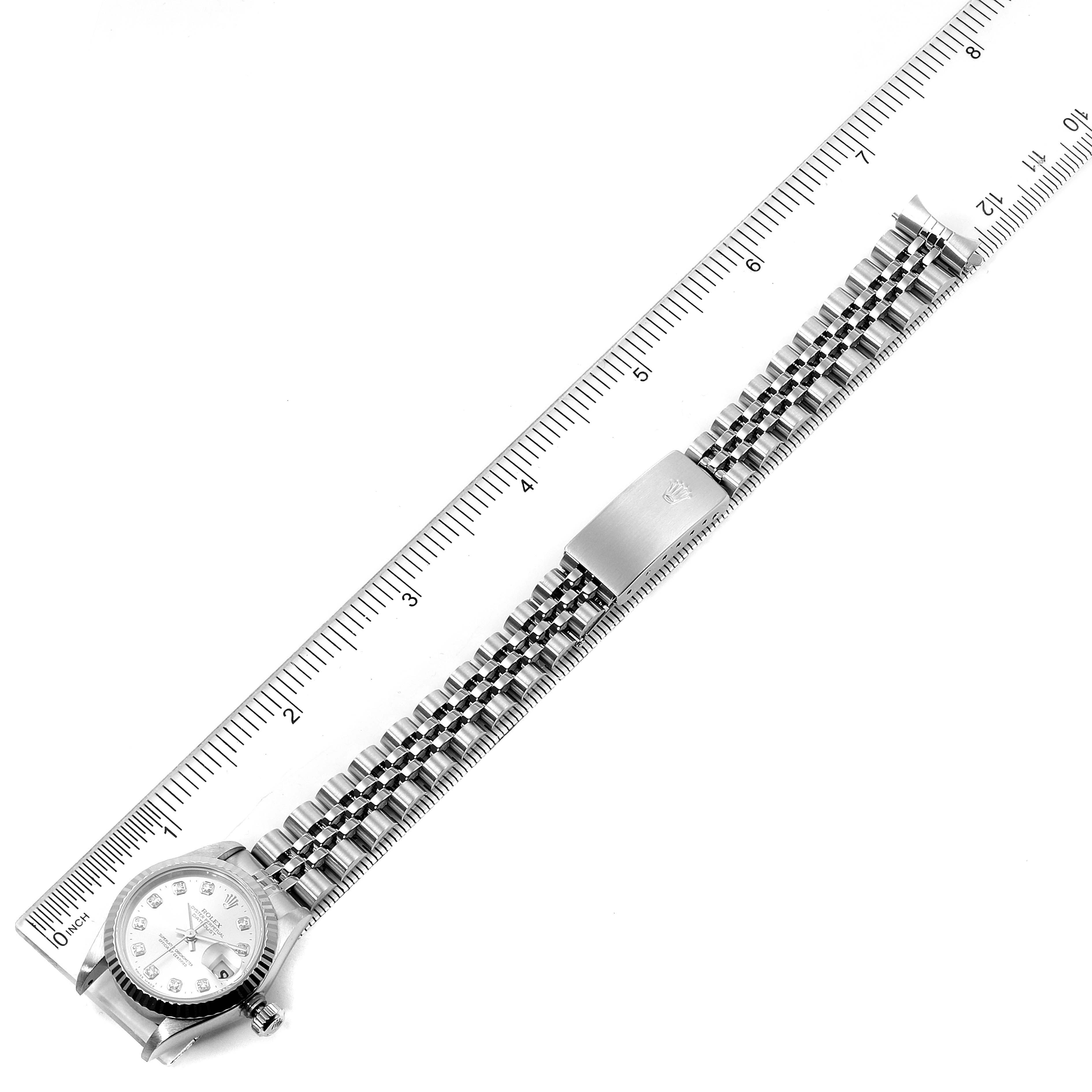 This image shows a Rolex Datejust 69174 Women's Stainless Steel Silver Dial 69174 Women's Stainless Steel Silver Dial watch laid flat with the face, crown, and full bracelet visible, aligned next to a ruler.