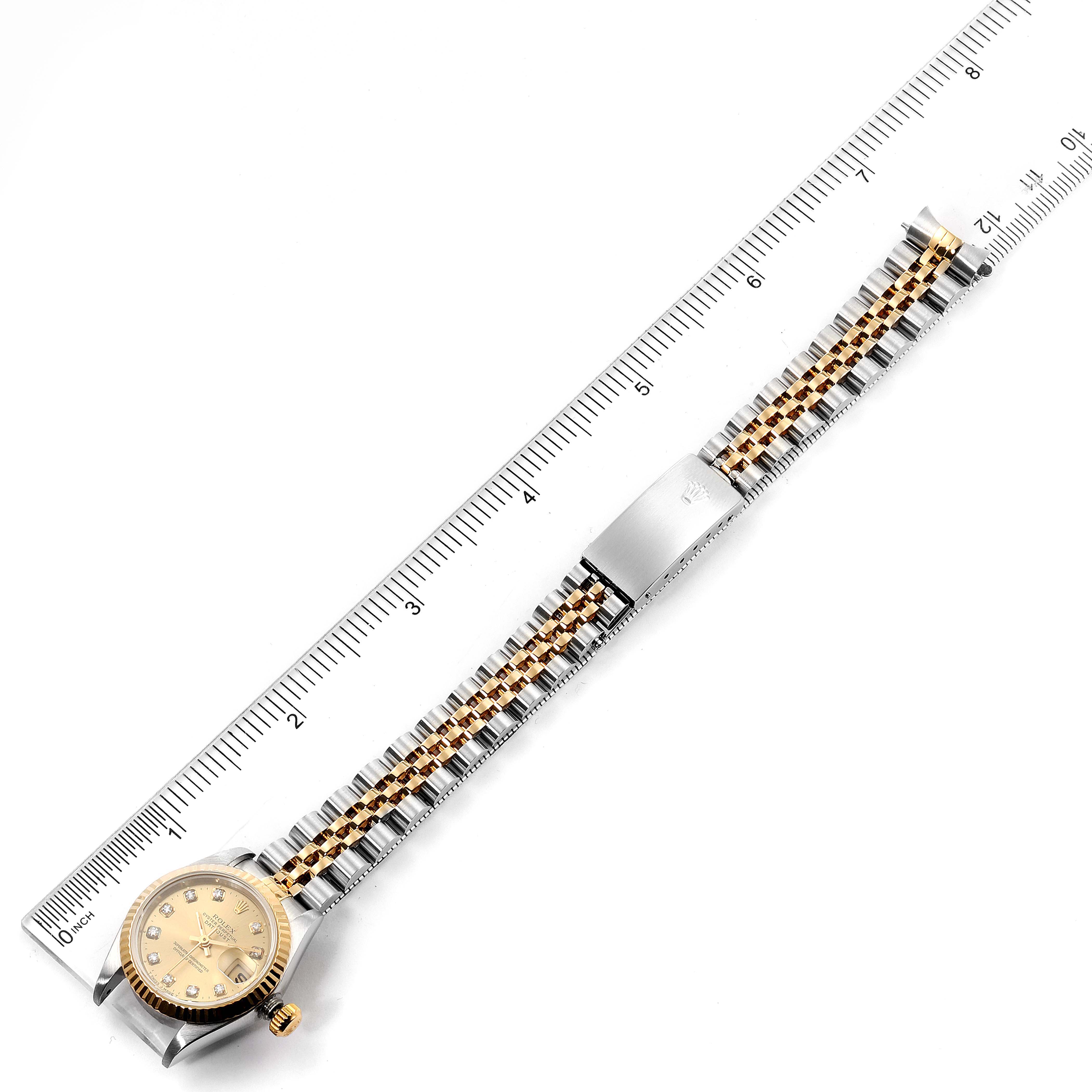 The image shows a Rolex Datejust 69173 Women's Steel and Gold (two tone) Champagne Dial 69173 Women's Steel and Gold (two tone) Champagne Dial watch laid flat alongside a ruler, displaying the face, band, and clasp.