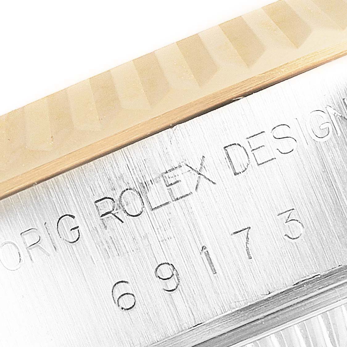 The image shows a close-up of the Rolex logo and model number on the side of a Rolex Datejust 69173 Women's Steel and Gold (two tone) Champagne Dial 69173 Women's Steel and Gold (two tone) Champagne Dial watch case and bezel.