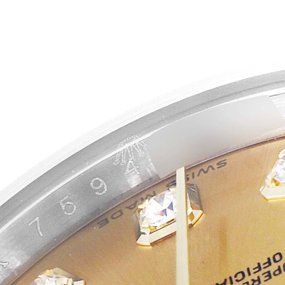 This close-up image of the Rolex Datejust 179173 Women's Steel and Gold (two tone) Champagne Dial 179173 Women's Steel and Gold (two tone) Champagne Dial watch shows part of the dial with diamond markers and a portion of the rehaut with engraved numbers.