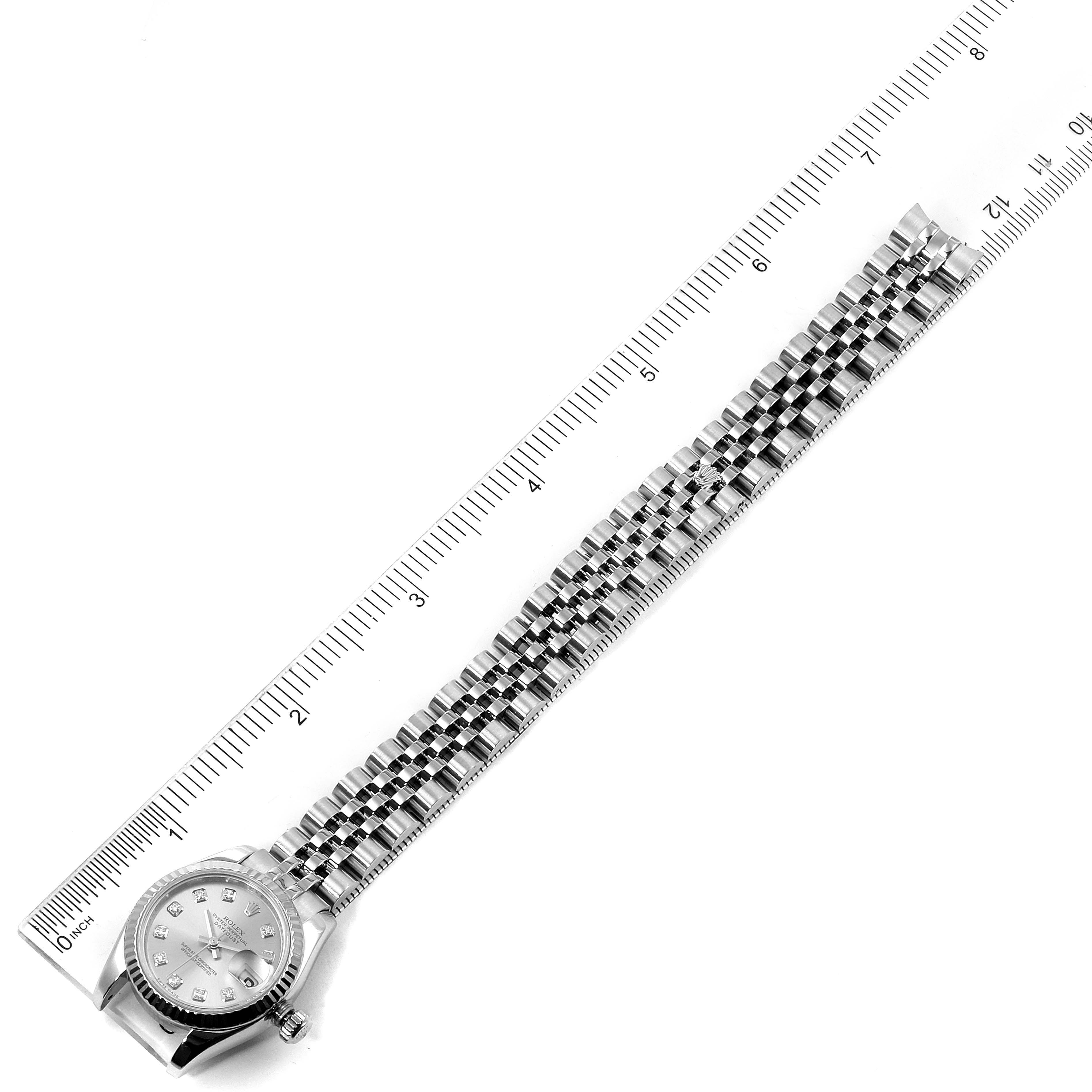 The image shows a top-down view of the Rolex Datejust 179174 Women's Stainless Steel Silver Dial 179174 Women's Stainless Steel Silver Dial watch displaying its dial and full bracelet alongside a ruler.