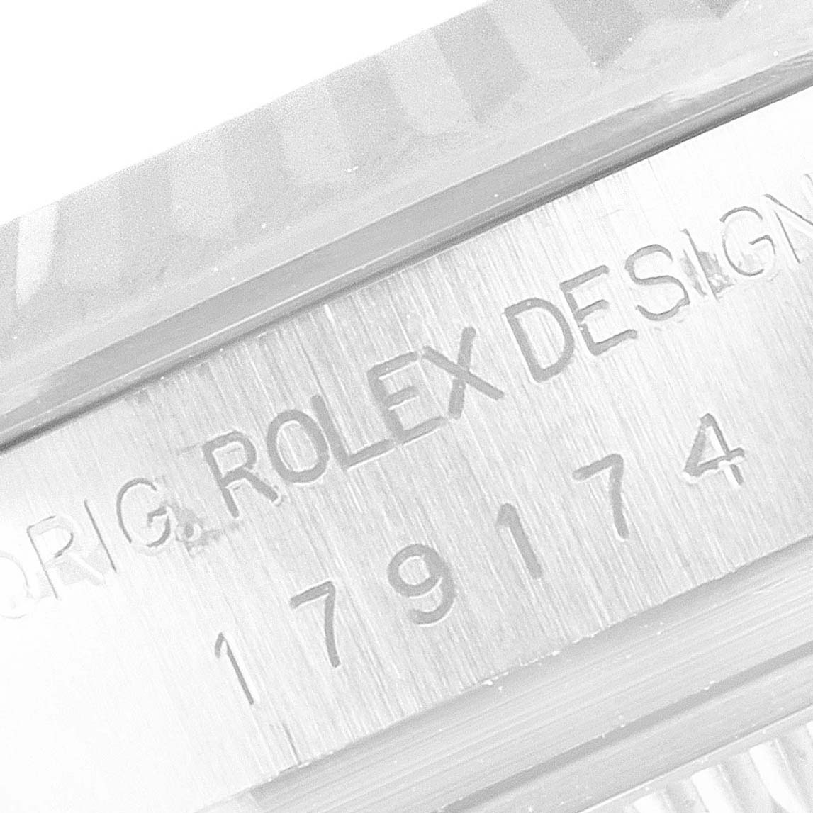 The image shows a macro close-up of the Rolex Datejust 179174 Women's Stainless Steel Silver Dial 179174 Women's Stainless Steel Silver Dial watch case, highlighting the engraved "Rolex Design" and model number.