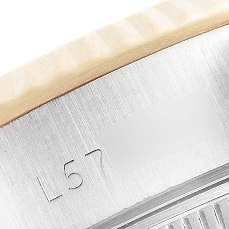 This image shows a close-up of the side view of a Rolex Datejust 69173 Women's Steel and Gold (two tone) Champagne Dial 69173 Women's Steel and Gold (two tone) Champagne Dial watch, highlighting its bezel and engraved serial number.