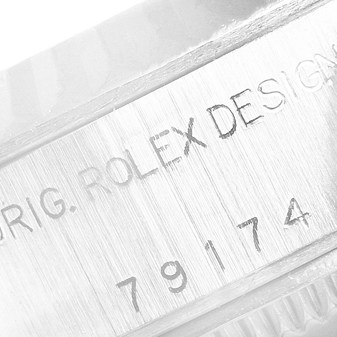 The image shows a close-up angle of the case side of a Rolex Datejust 79174 Women's Stainless Steel White Dial 79174 Women's Stainless Steel White Dial watch, displaying the engravings.