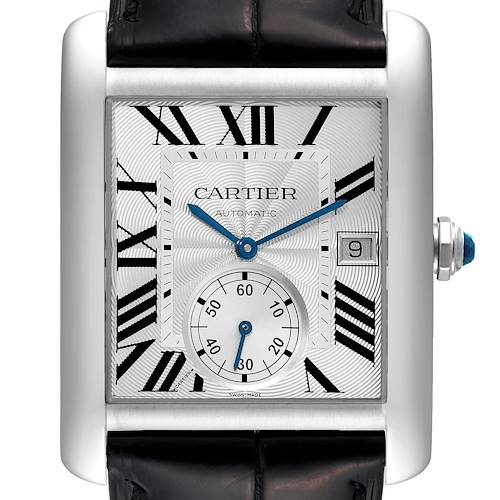 The Tank MC model by Cartier is shown from a front angle, displaying the watch face, Roman numerals, blue hands, and date window.