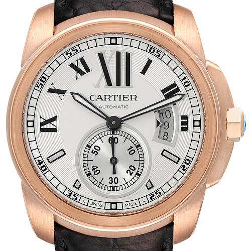 The image shows a front view of the Calibre de Cartier watch by Cartier, featuring the dial, hands, bezel, and part of the leather strap.