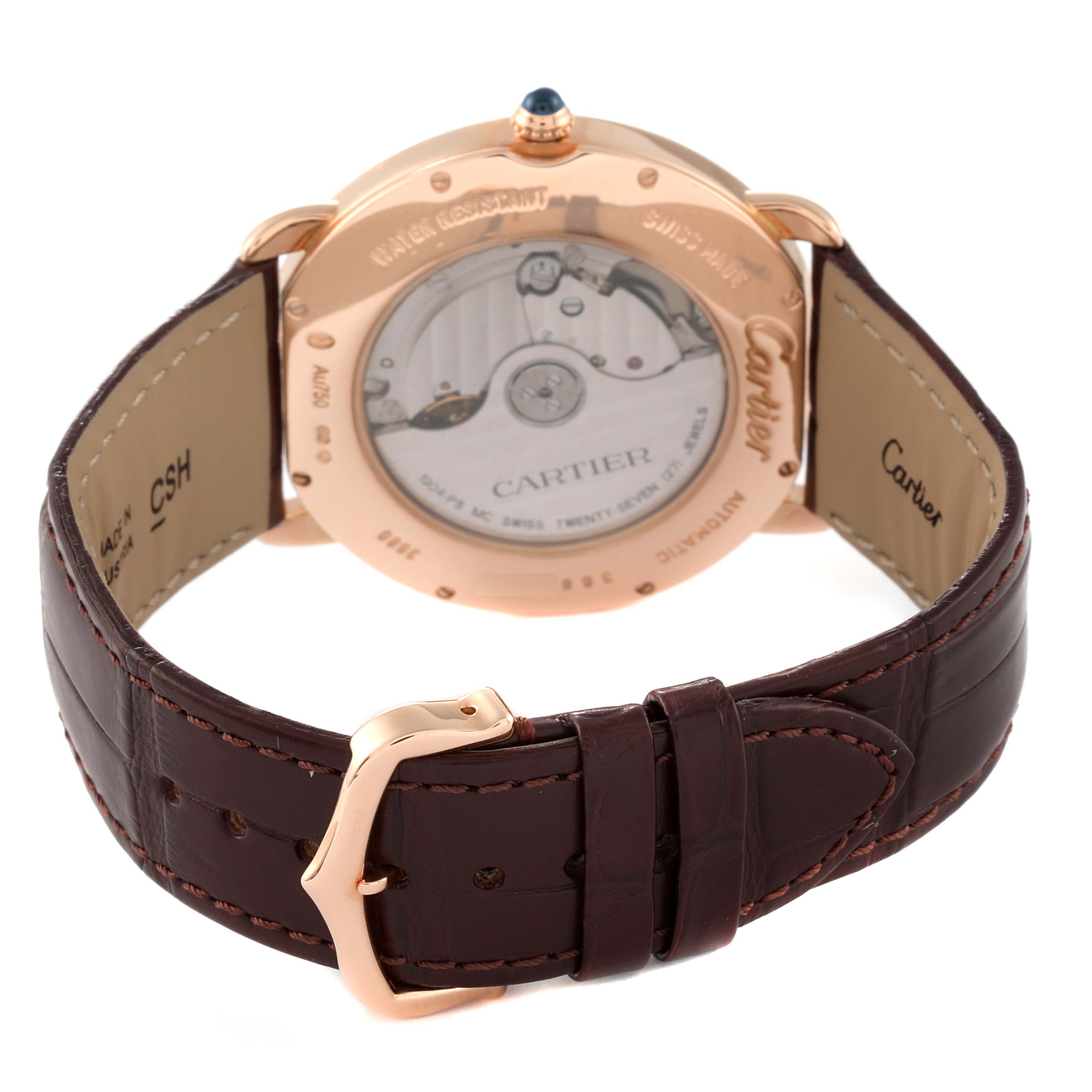 The image shows the back of a Cartier Ronde W6801005 Men's Rose Gold Silver Dial W6801005 Men's Rose Gold Silver Dial watch, highlighting its transparent case, movement, and brown leather strap clasp. 
