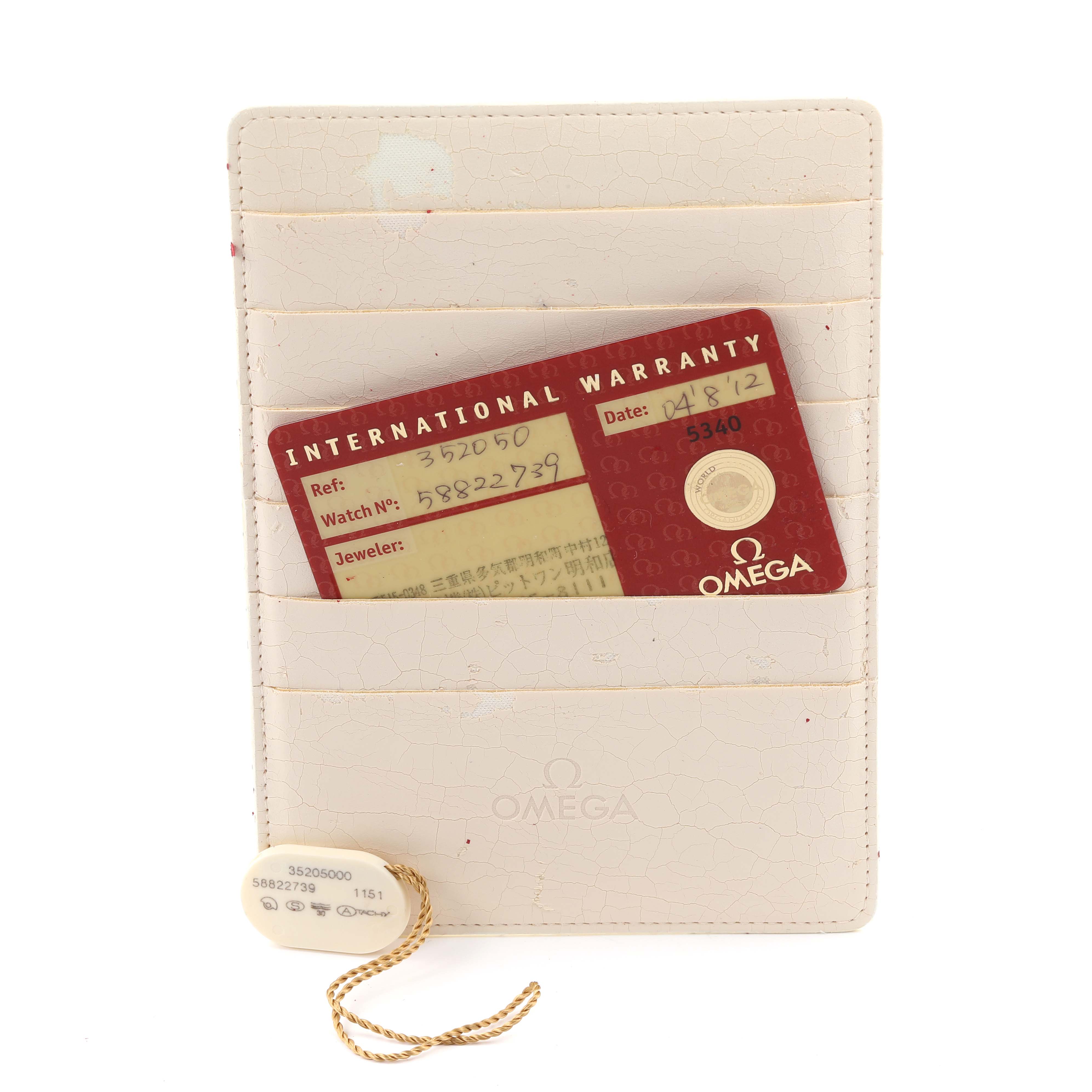 The image shows an Omega Speedmaster 3520.50.00 Men's Stainless Steel Black Dial 3520.50.00 Men's Stainless Steel Black Dial warranty card and a tag, both resting on a white holder.