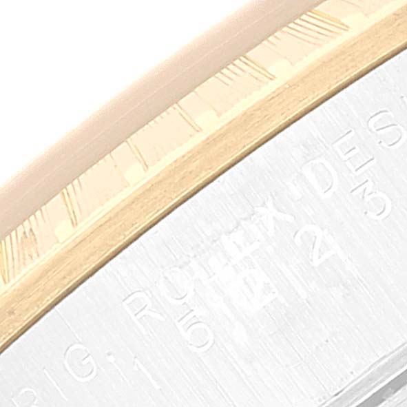 The image shows a close-up of the bezel and part of the engraved case of a Rolex Date 15223 Men's Steel and Gold (two tone) Champagne Dial 15223 Men's Steel and Gold (two tone) Champagne Dial watch.
