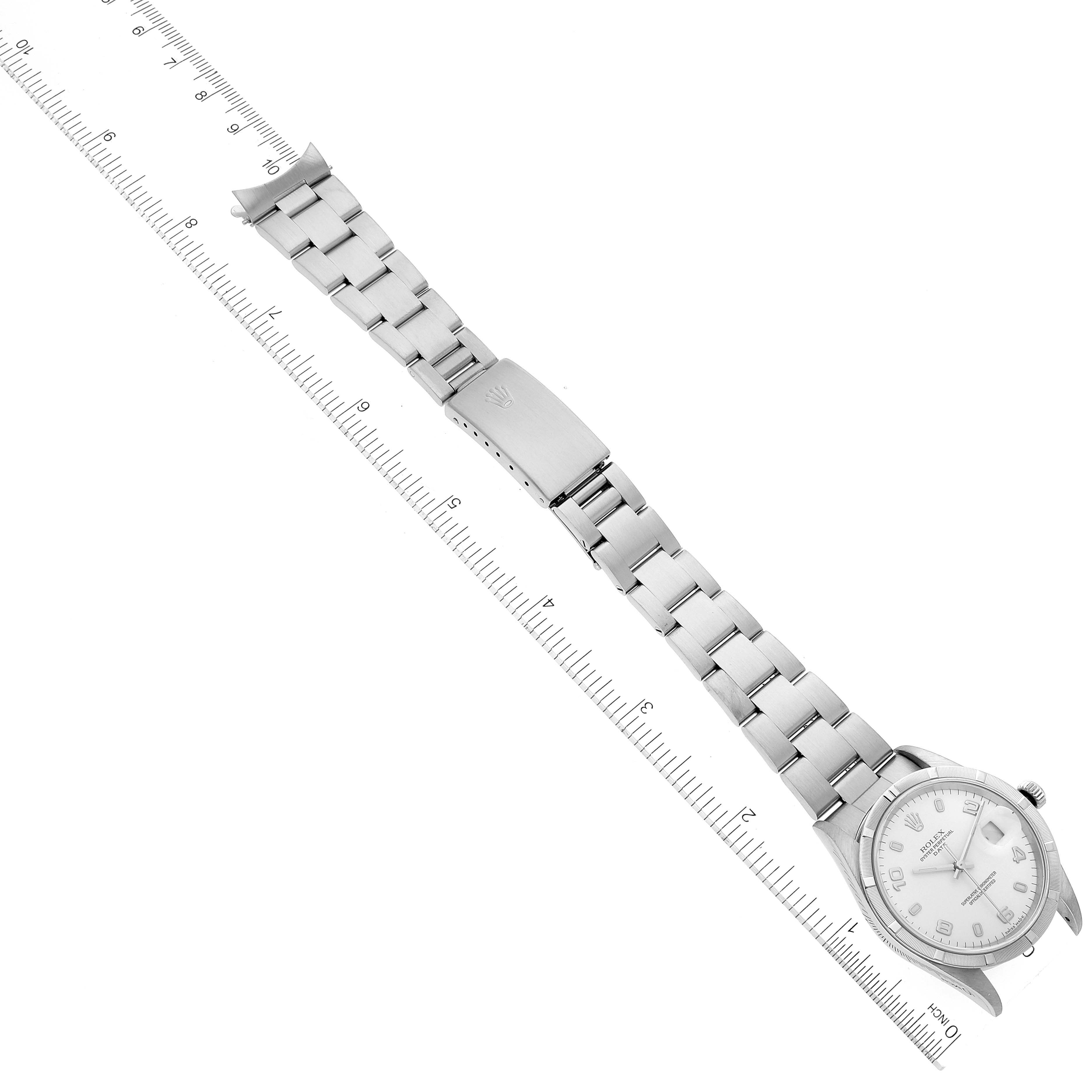 This image shows a Rolex Date 15210 Men's Stainless Steel White Dial 15210 Men's Stainless Steel White Dial model watch placed beside a ruler, including its bracelet and clasp.