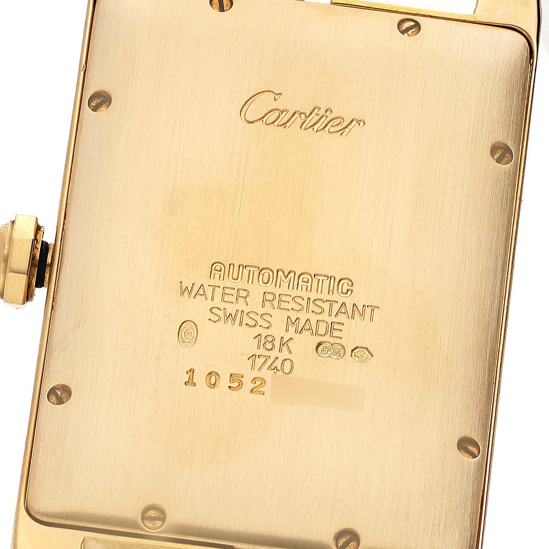 This image shows the back case of the Cartier Tank Americaine W2603156 Men's Yellow Gold Silver Dial W2603156 Men's Yellow Gold Silver Dial watch, highlighting the inscriptions and gold finish.