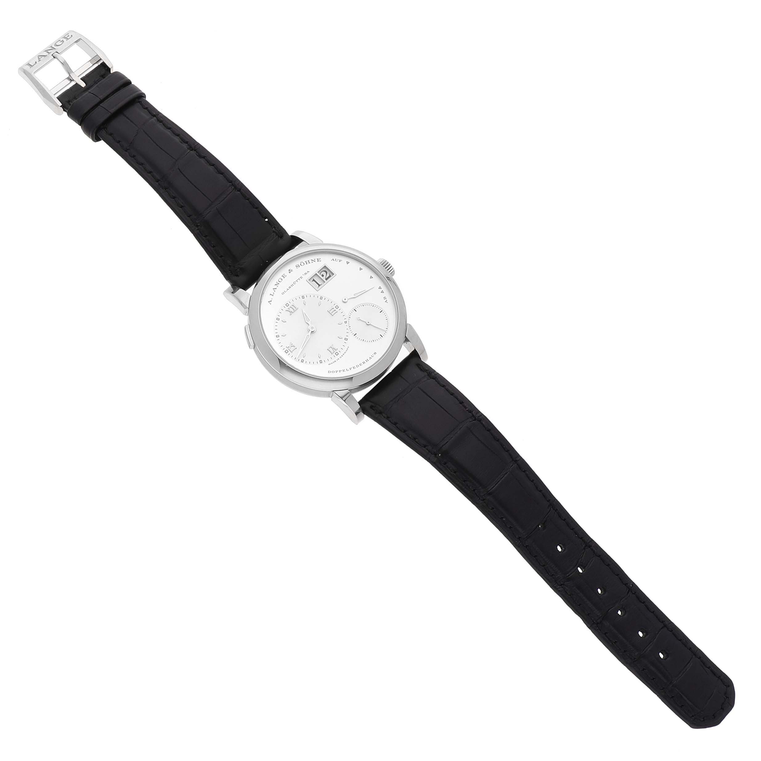 The A. Lange & Sohne Lange 1 191.039 Men's White Gold Silver Dial watch is shown from a top-down angle, displaying the face and full black leather strap.