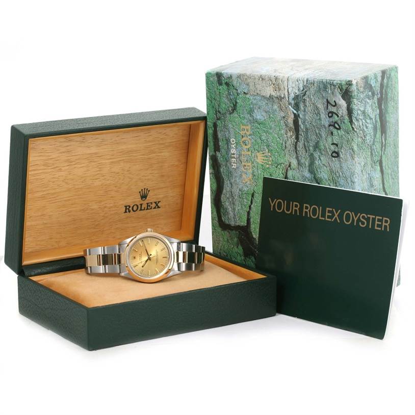 The image shows a Rolex Oyster Perpetual 14203 Men's Steel and Gold (two tone) Champagne Dial 14203 Men's Steel and Gold (two tone) Champagne Dial watch, its box, outer case, and accompanying booklet.