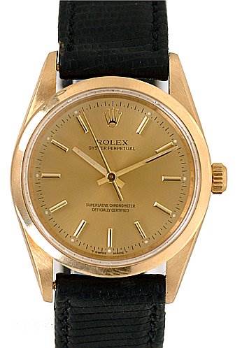 This image shows a front view of a Rolex Oyster Perpetual 14208 Men's Yellow Gold Champagne Dial 14208 Men's Yellow Gold Champagne Dial watch with a gold dial, gold case, and a black strap.